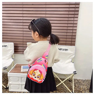 Child wearing pink Paw Patrol chest bag, featuring cartoon character, ideal for kids outdoor activities and costumes.
