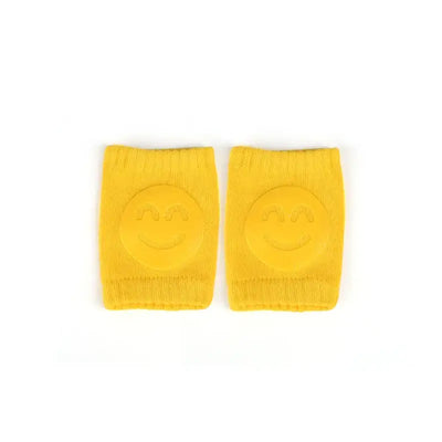 Yellow baby knee pads with smiley face design for crawling infants and toddlers, perfect for leg protection.