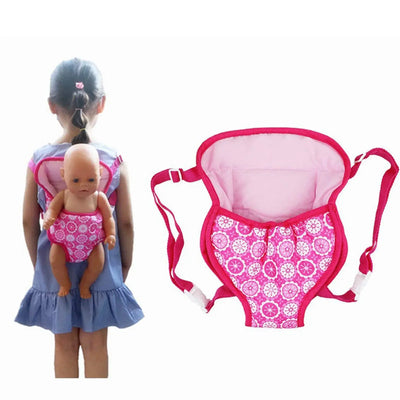 Child wearing a pink doll carrier backpack with a baby doll on her back, showcasing a fun floral design.