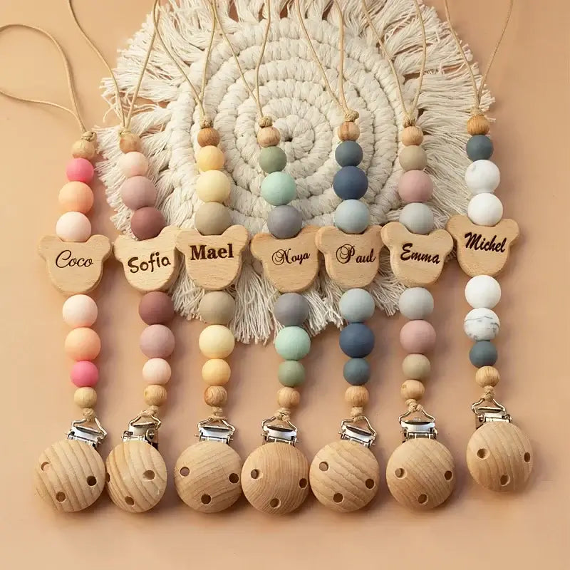 Personalized wooden pacifier chain with colorful silicone beads, custom names for newborns, and teething safety.