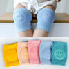 Colorful baby knee pads for crawling, featuring smiley face designs in blue, yellow, pink, and green, suitable for infants.