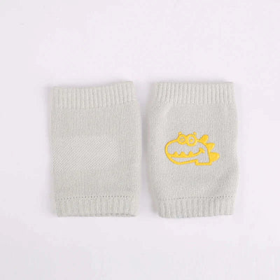 Baby knee pads in light gray with cute yellow dinosaur design, perfect for crawling infants, providing comfort and protection.