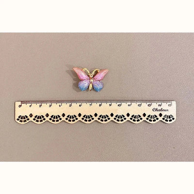Colorful butterfly hairpin displayed above a ruler for size reference, showcasing a cute accessory for girls.
