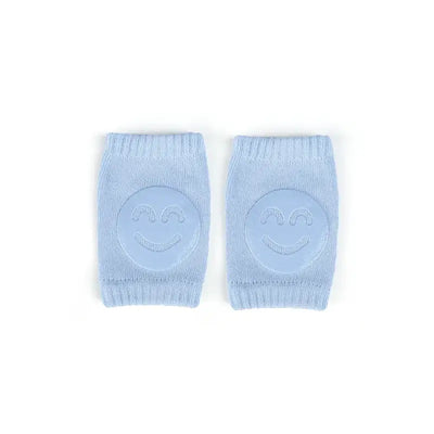 Baby knee pads in light blue with smiley face design, perfect for crawling infants and toddlers, providing comfort and protection.