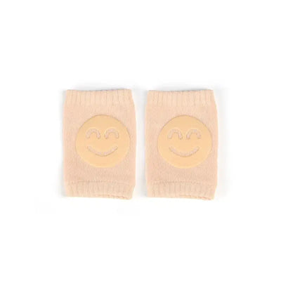 Baby knee pads with smiley face design, non-slip crawling cushion for infants and toddlers, beige color.